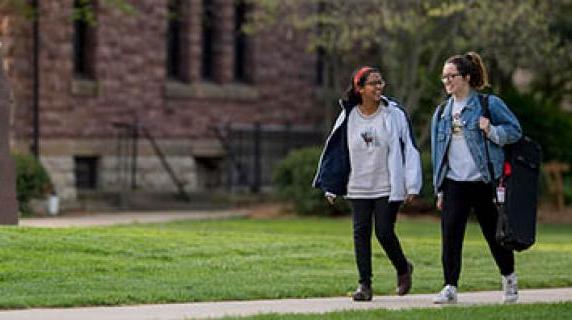 two students walk near Goodnow Hall